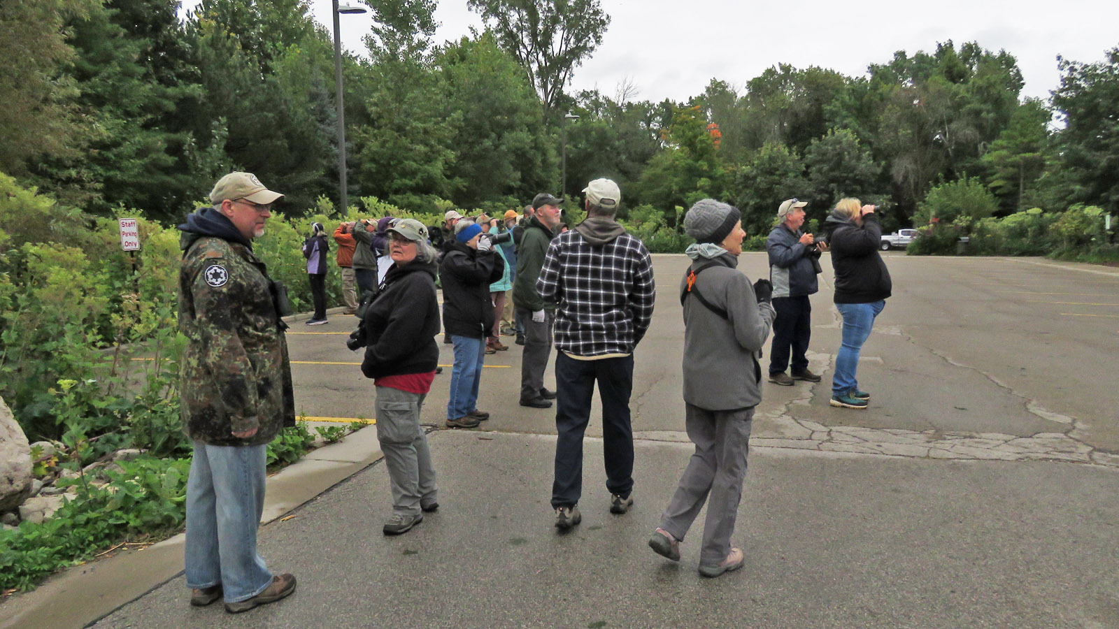A group of about 20 people gathers at Bay Beach Wildlife Sanctuary